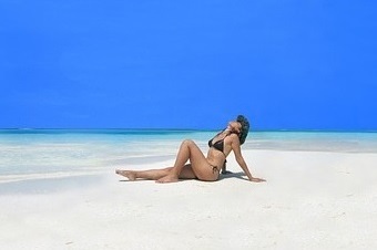 砂浜に座るビキニの女性